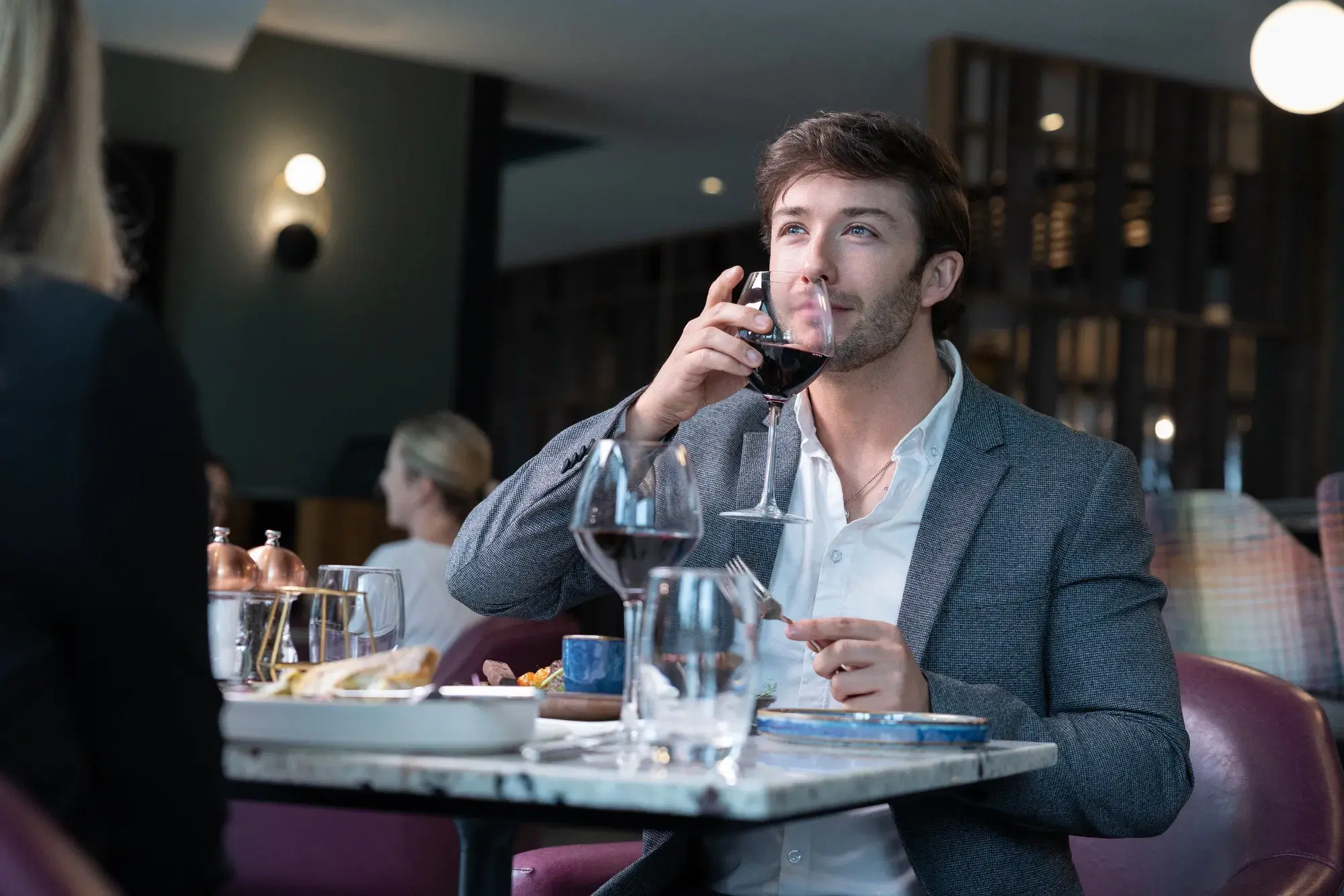 Guest enjoying a glass of red wine at Mossco